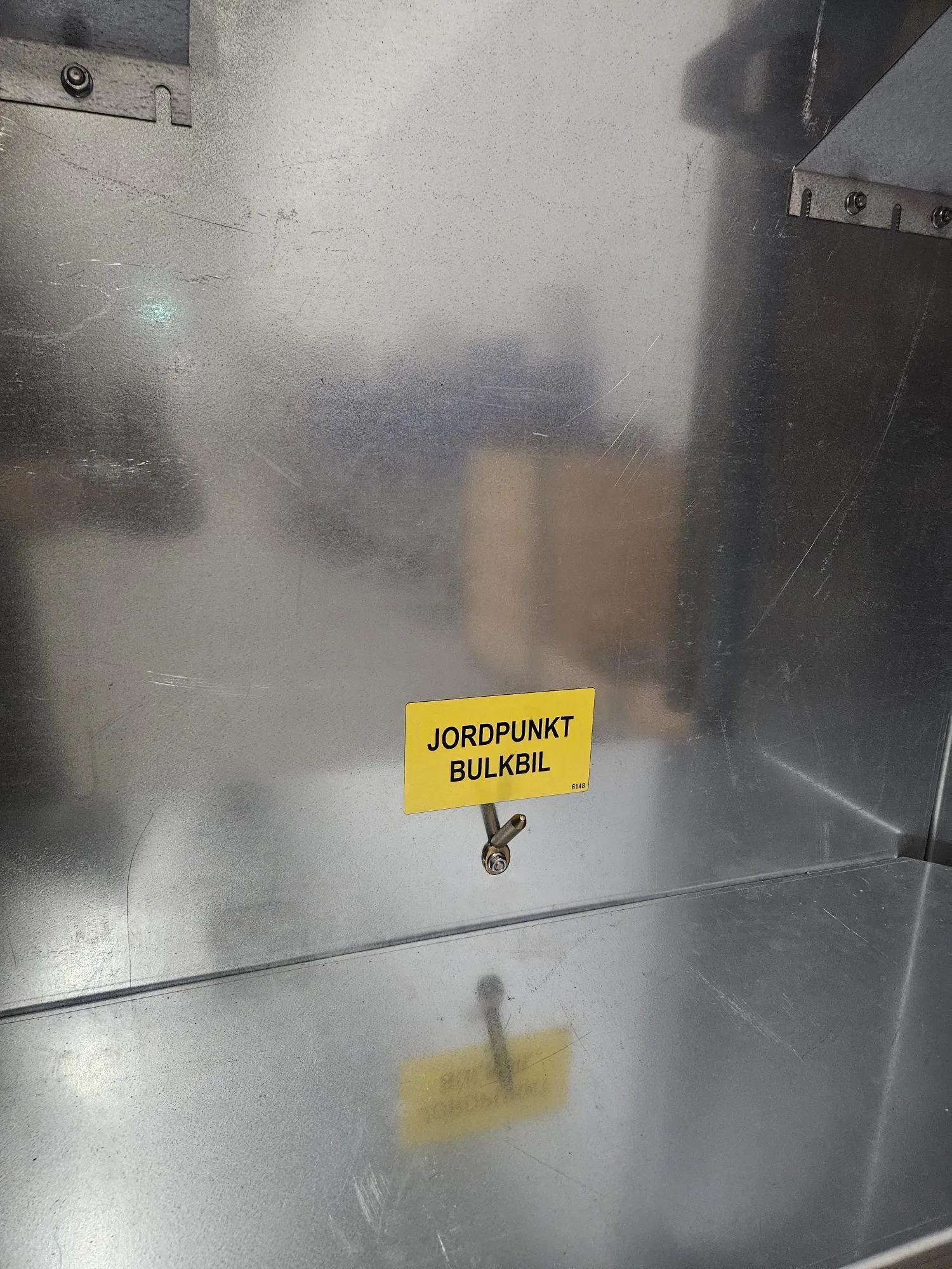 Insidan av påfyllningsskåpet med jordningspunkt för tankbil.