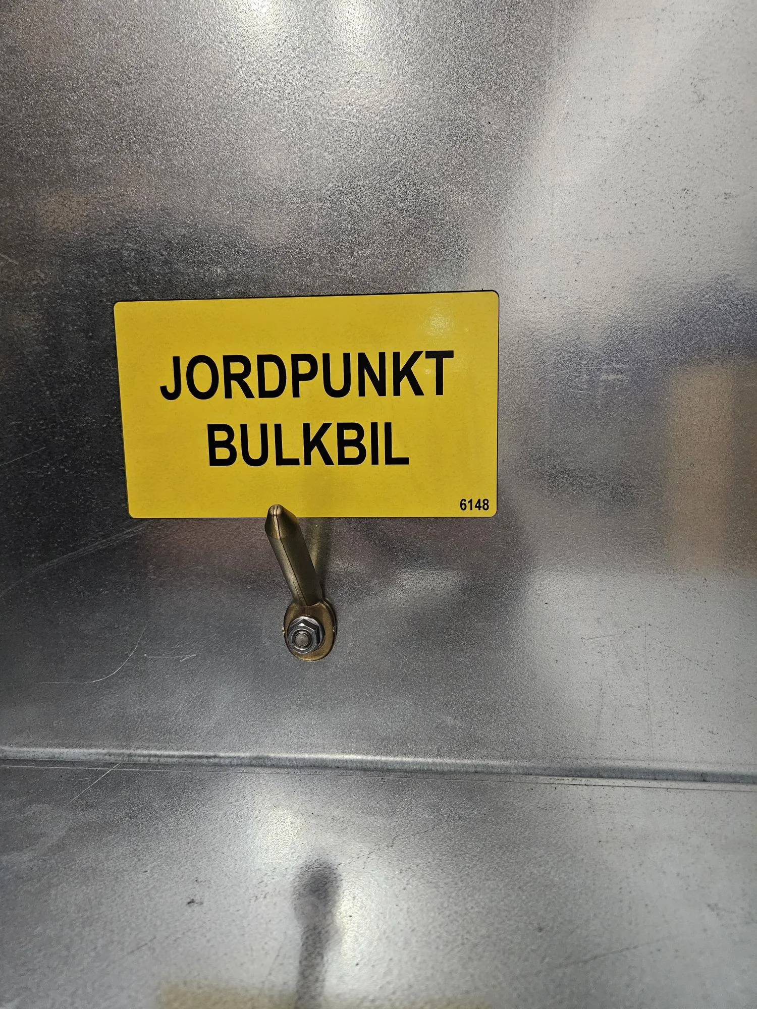Jordningspunkt för bulkbil på skåpet för påfyllningsröret.